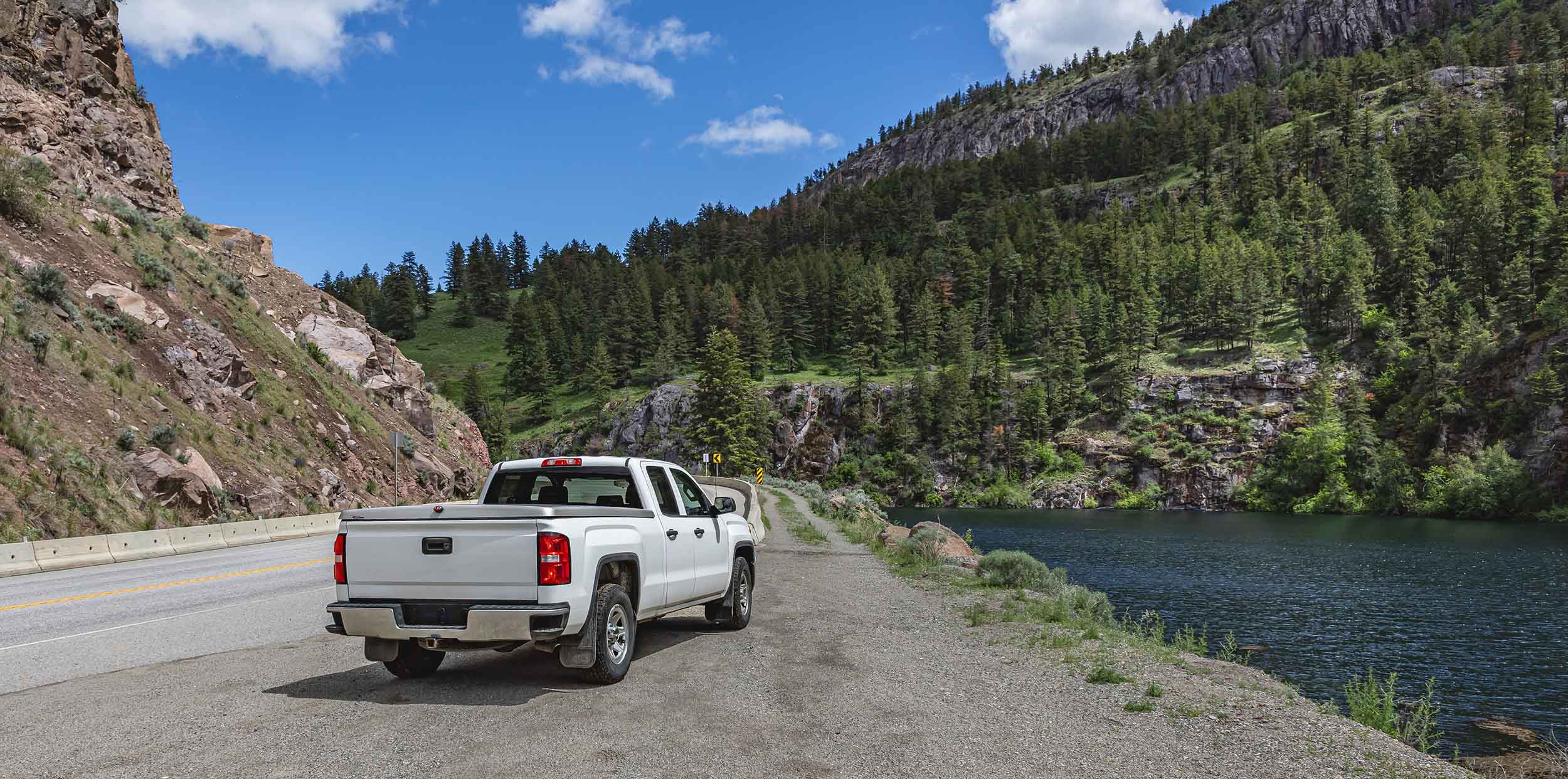 white pickup truck, off road in the mountains, looking over a beautiful landscape, lake